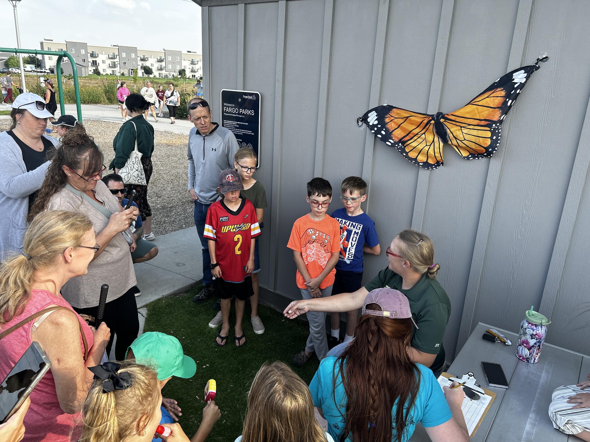 Monarch tagging photo with children and a monarch butterfly